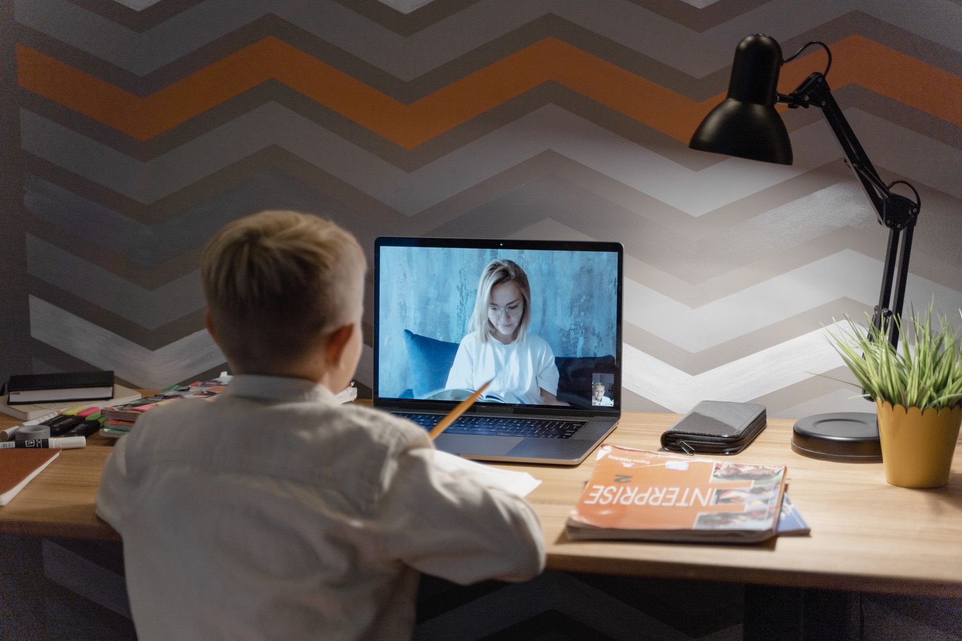 Person watching educational video content on a laptop at a desk