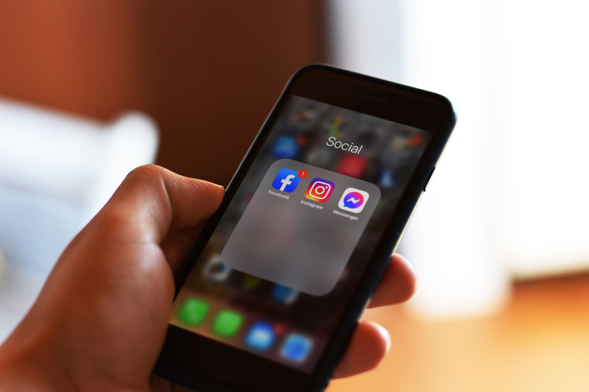 Hand holding smartphone scrolling through social media content feed