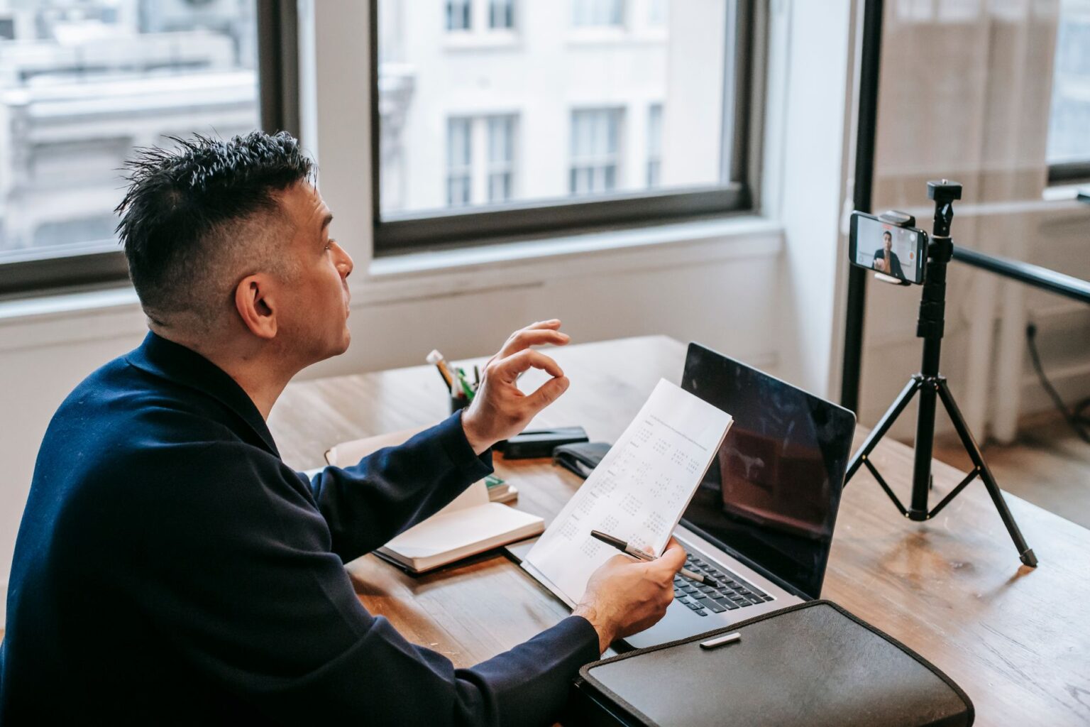 Professional team member on a video call taking notes during a client meeting