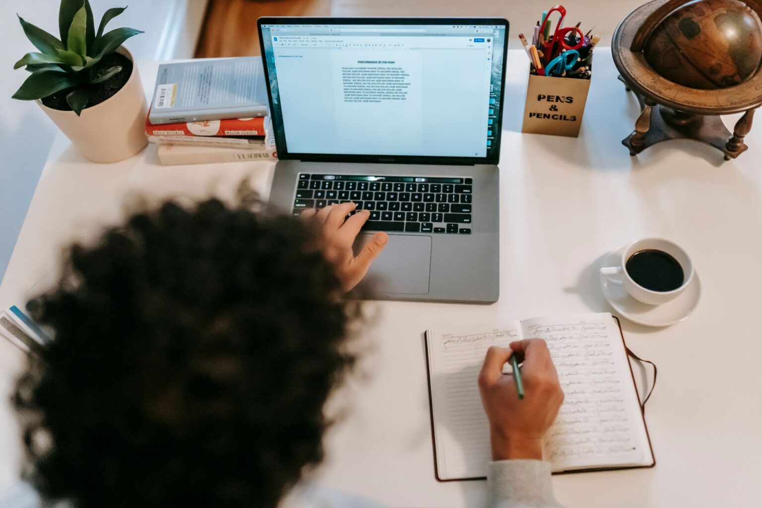 A writer working on a laptop at a clean desk, representing independent content creation