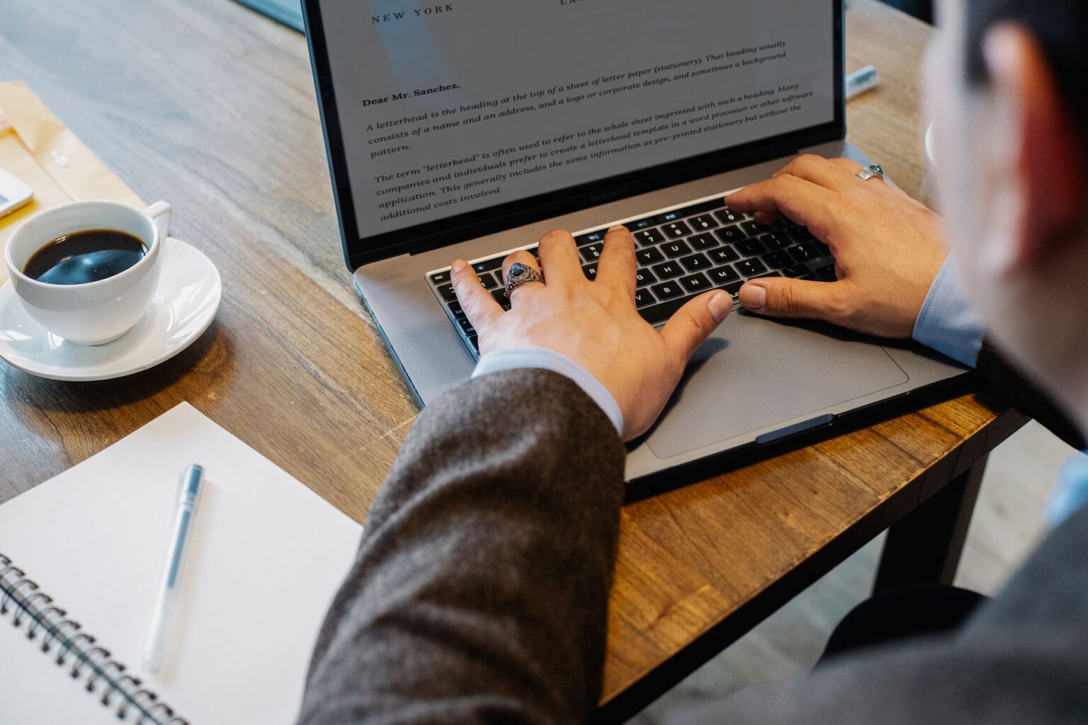 Person writing a newsletter on a laptop at a desk