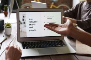 Gamma’s AI Deck Builder Is Quietly Replacing Google Slides for Marketers A person working on a presentation on a laptop at a modern desk