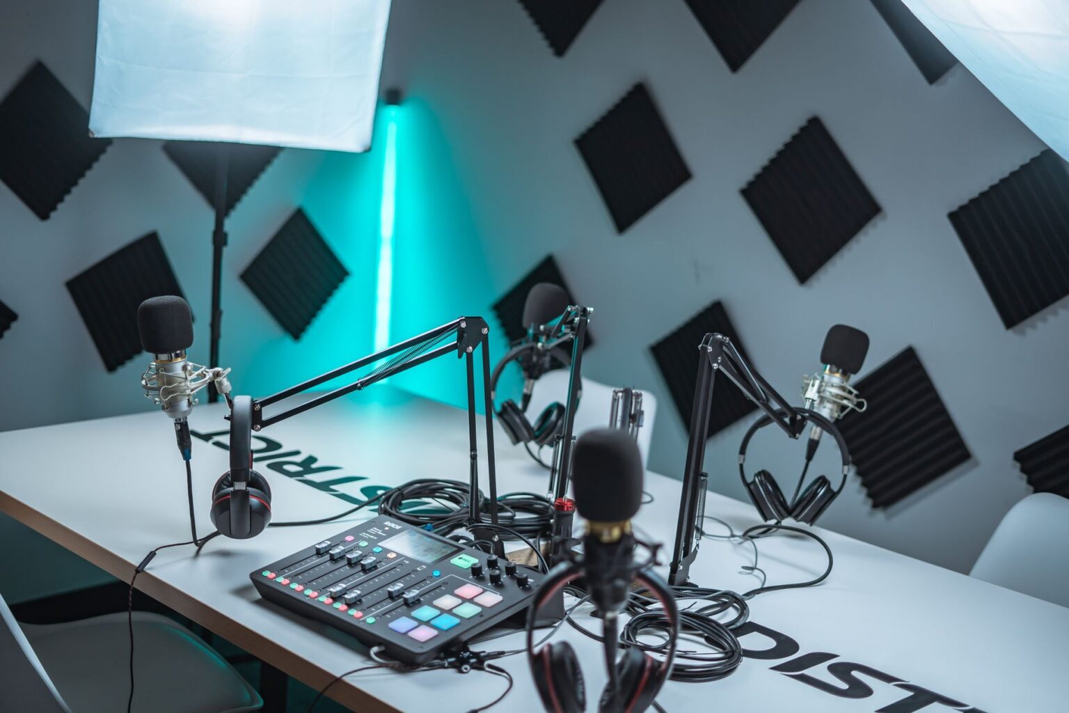 A remote podcast recording setup with microphone and laptop on a desk