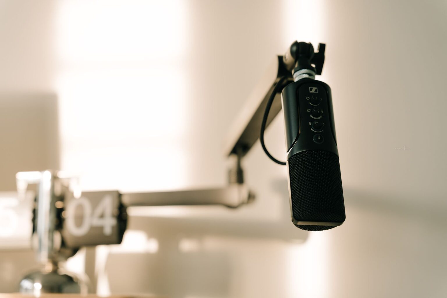 A podcaster recording an episode at a professional microphone setup in a home studio