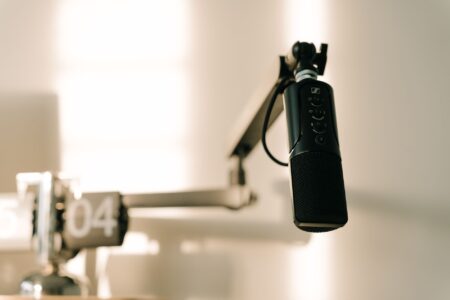 A podcaster recording an episode at a professional microphone setup in a home studio