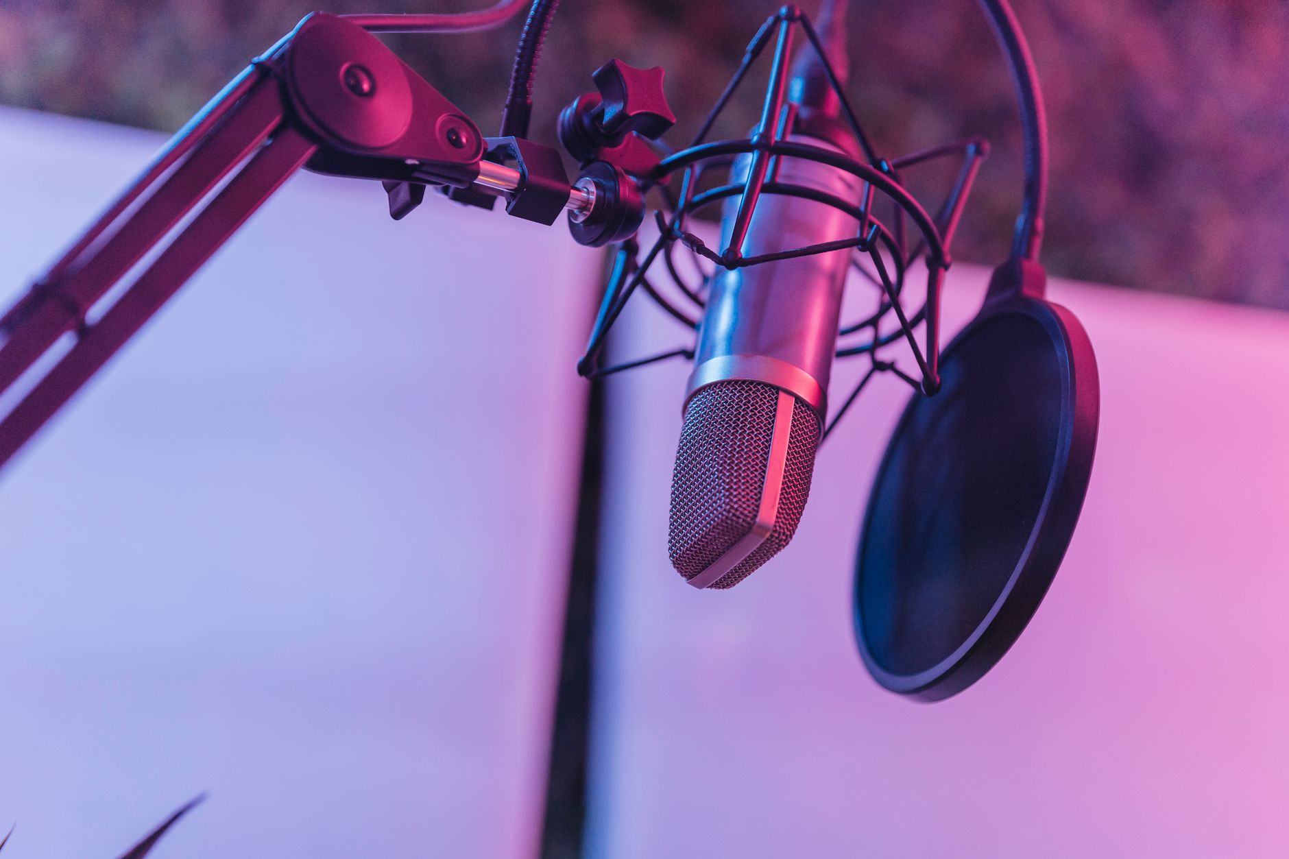 Person recording a podcast in a professional studio setup with microphone and headphones