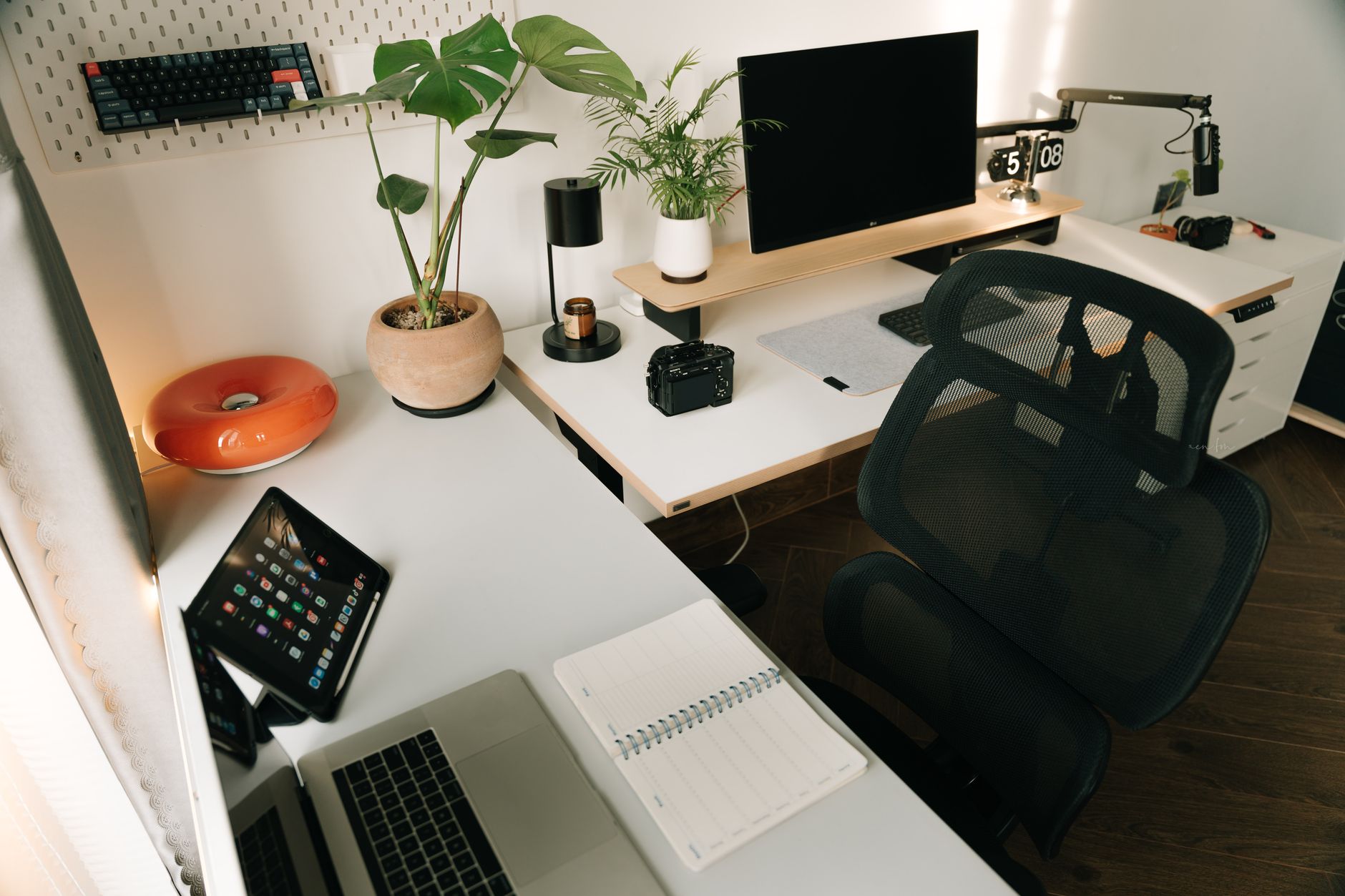 Clean desk workspace setup with laptop and notebook representing a solo creator's digital workflow