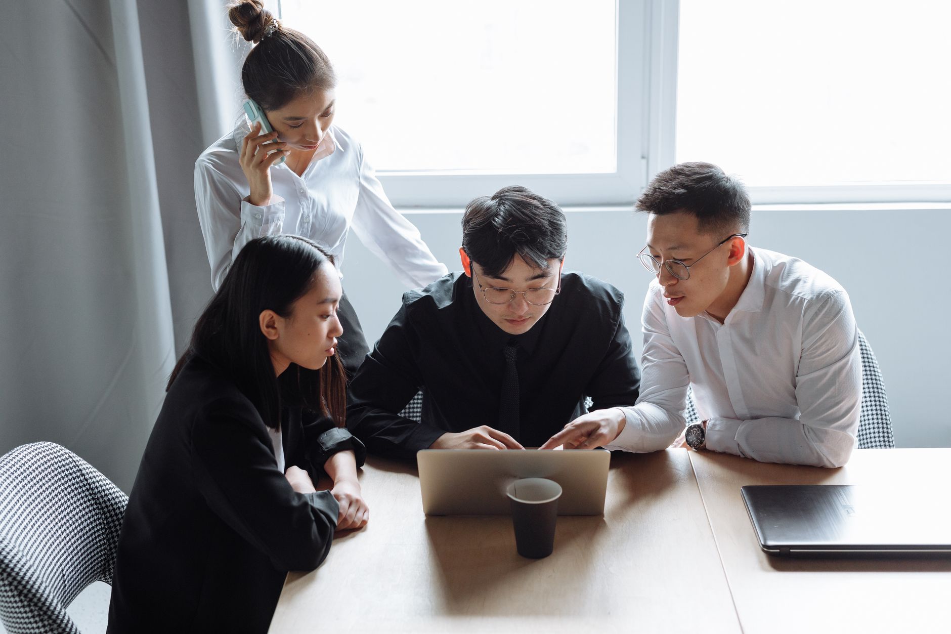 A group of business professionals reviewing data on laptops during an enterprise strategy meeting