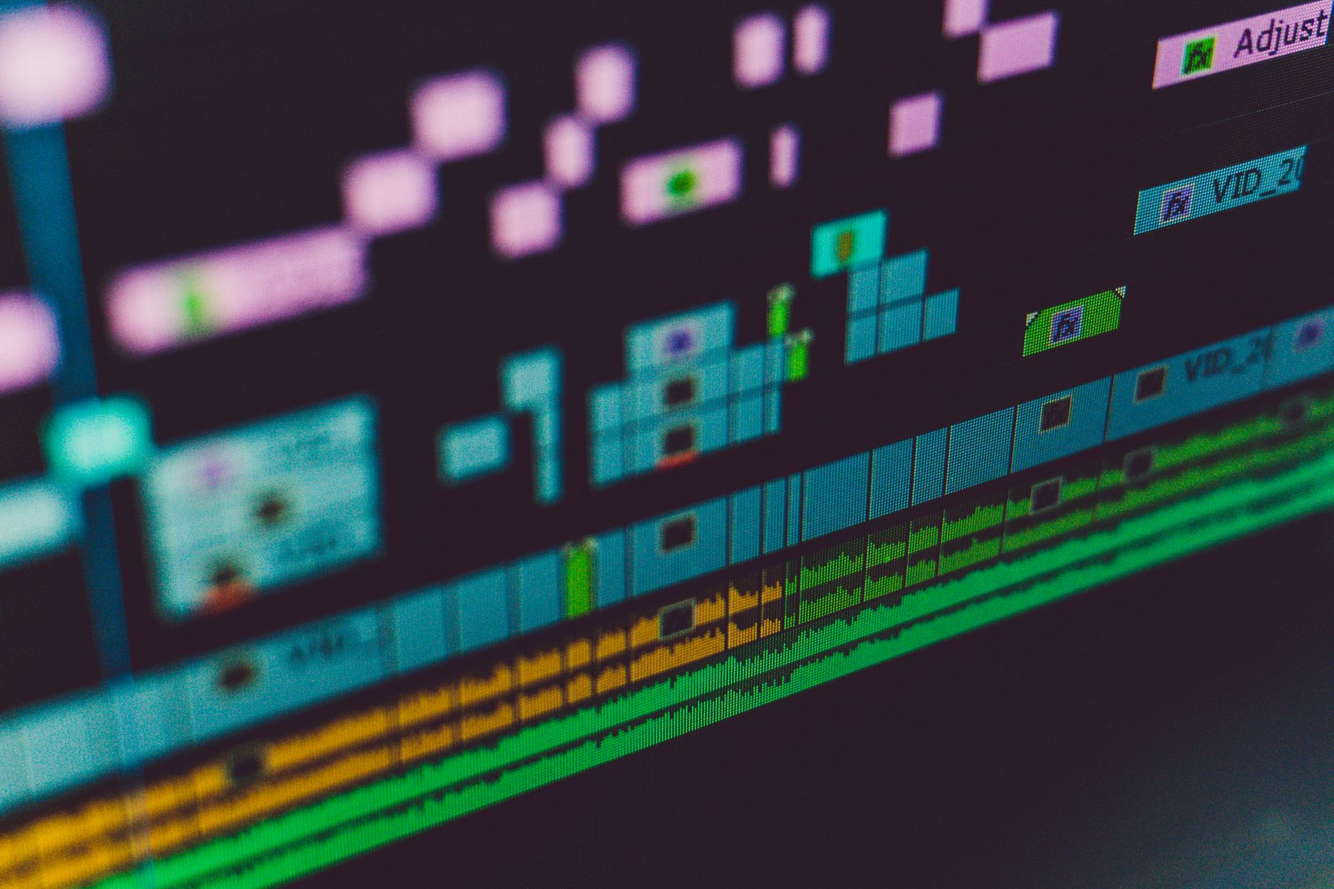 A content creator editing video clips on a desktop monitor with editing software open