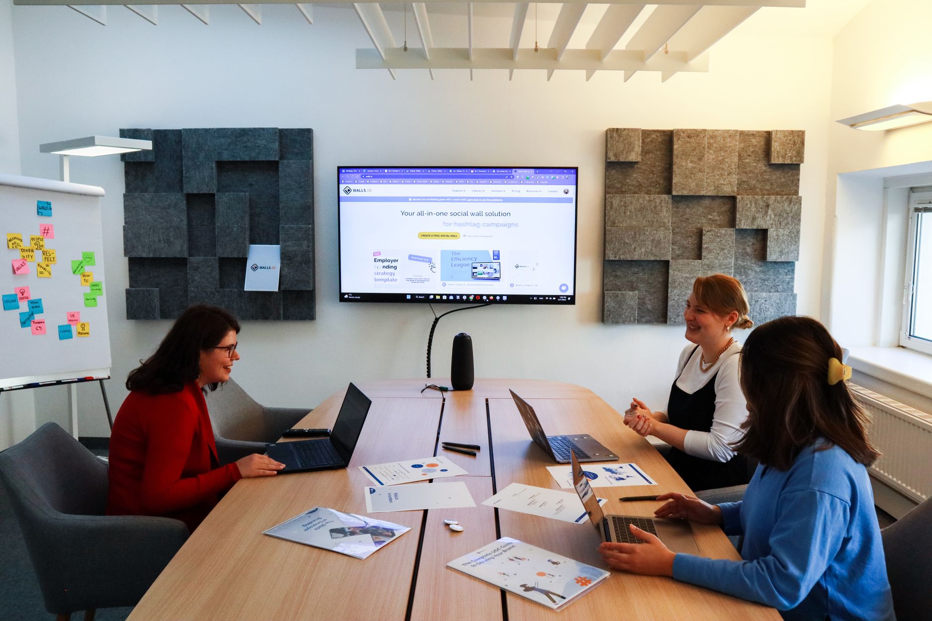 A small marketing team reviewing a digital content schedule together on a shared screen