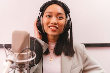 Podcaster recording in a professional studio setup with microphone and headphones