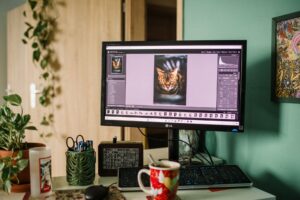 A marketer editing a product image on a laptop with design software open