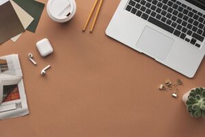 A clean desk workspace with a laptop open to a newsletter publishing dashboard