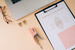 A designer working at a modern workspace surrounded by brand guidelines and digital screens
