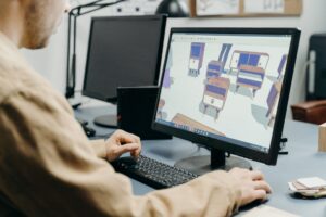 Designer reviewing a digital interface on a large monitor in a studio setting