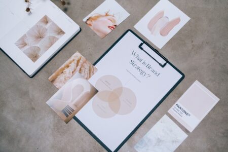 Designer working on brand identity materials at a desk with color swatches and a laptop