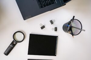 A clean desk workspace with a laptop open to a research document