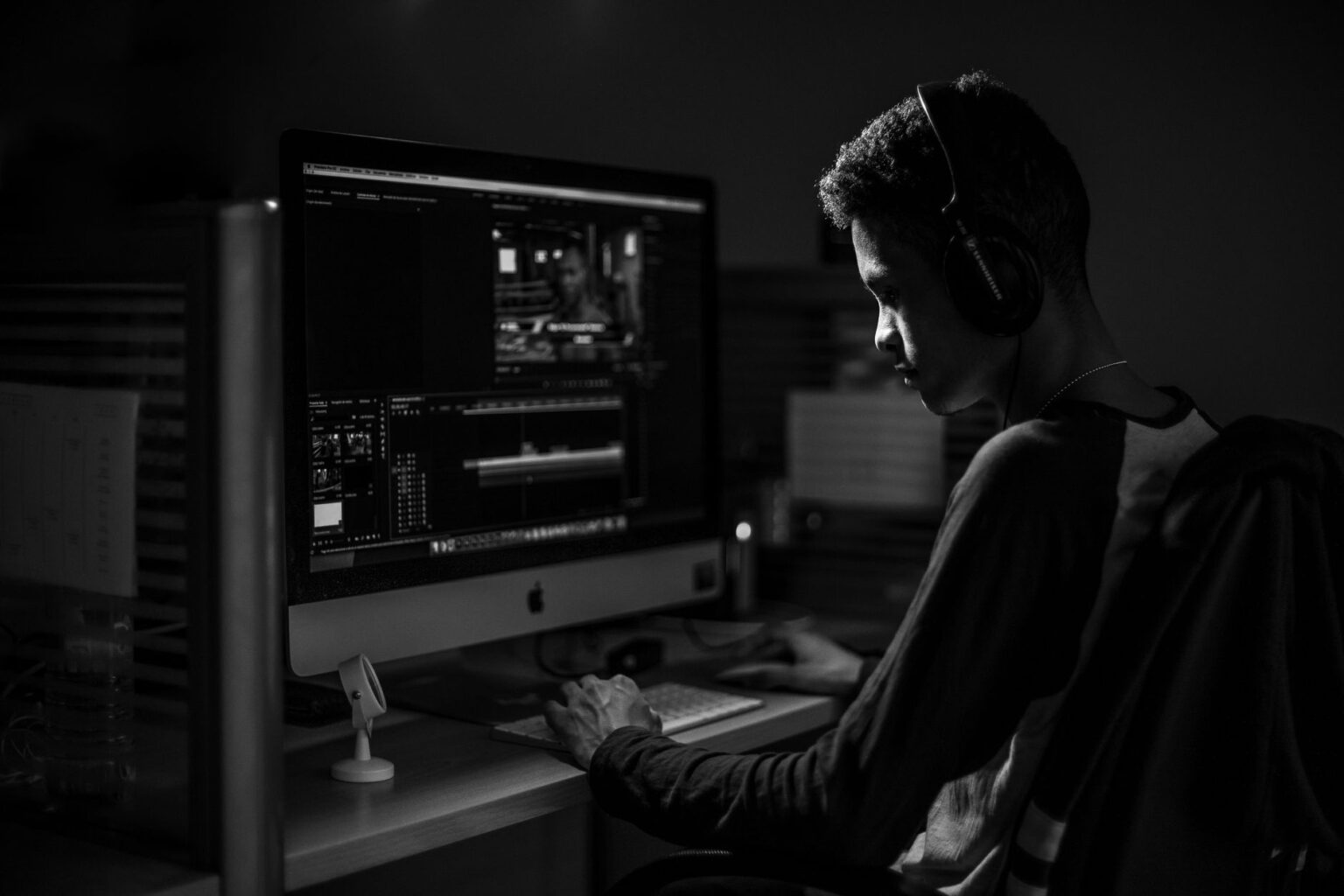 A marketer working at a desk editing video content on a computer screen