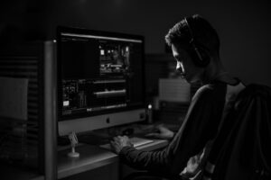 A marketer working at a desk editing video content on a computer screen