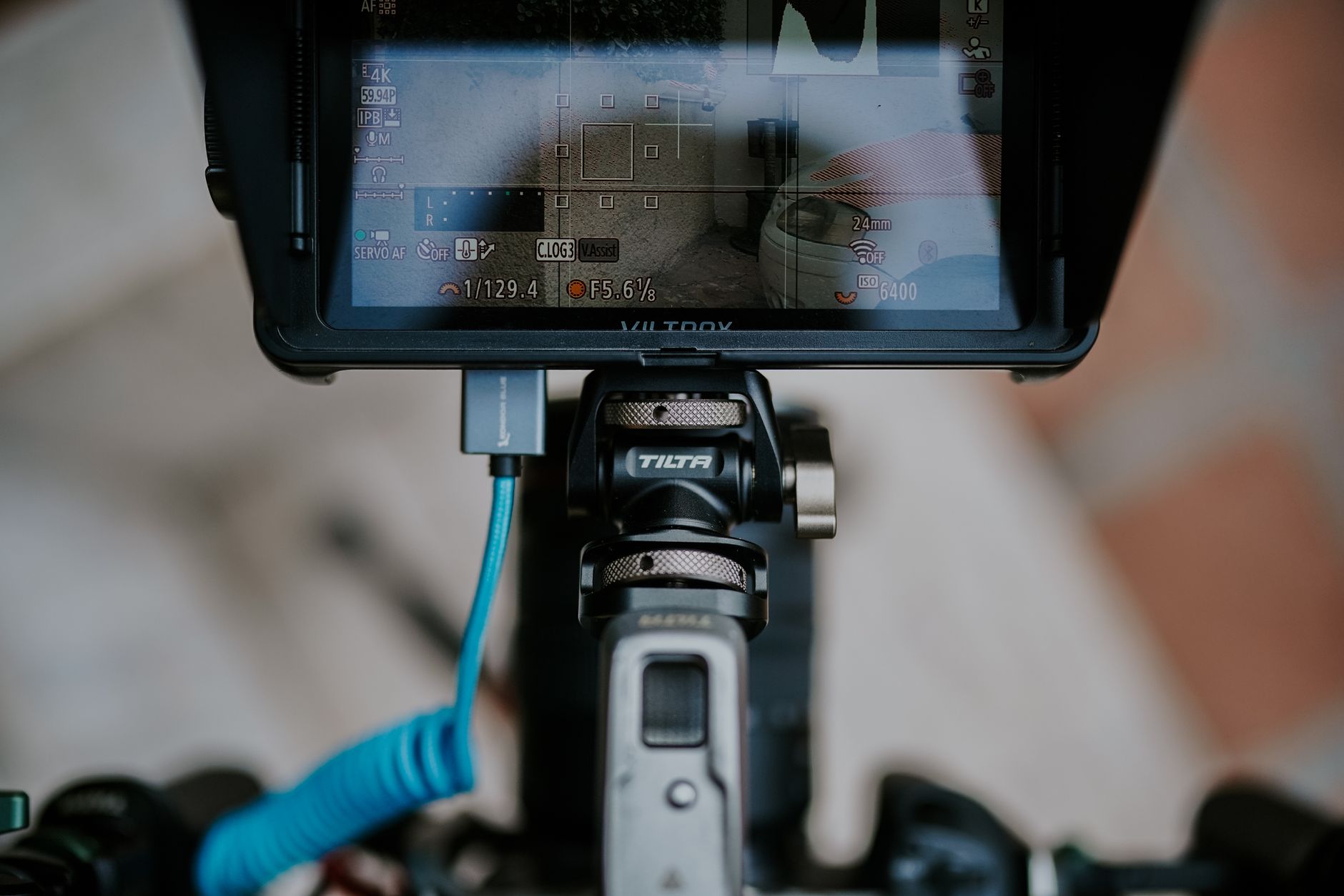 A video creator recording content at a desk with a camera and monitor setup