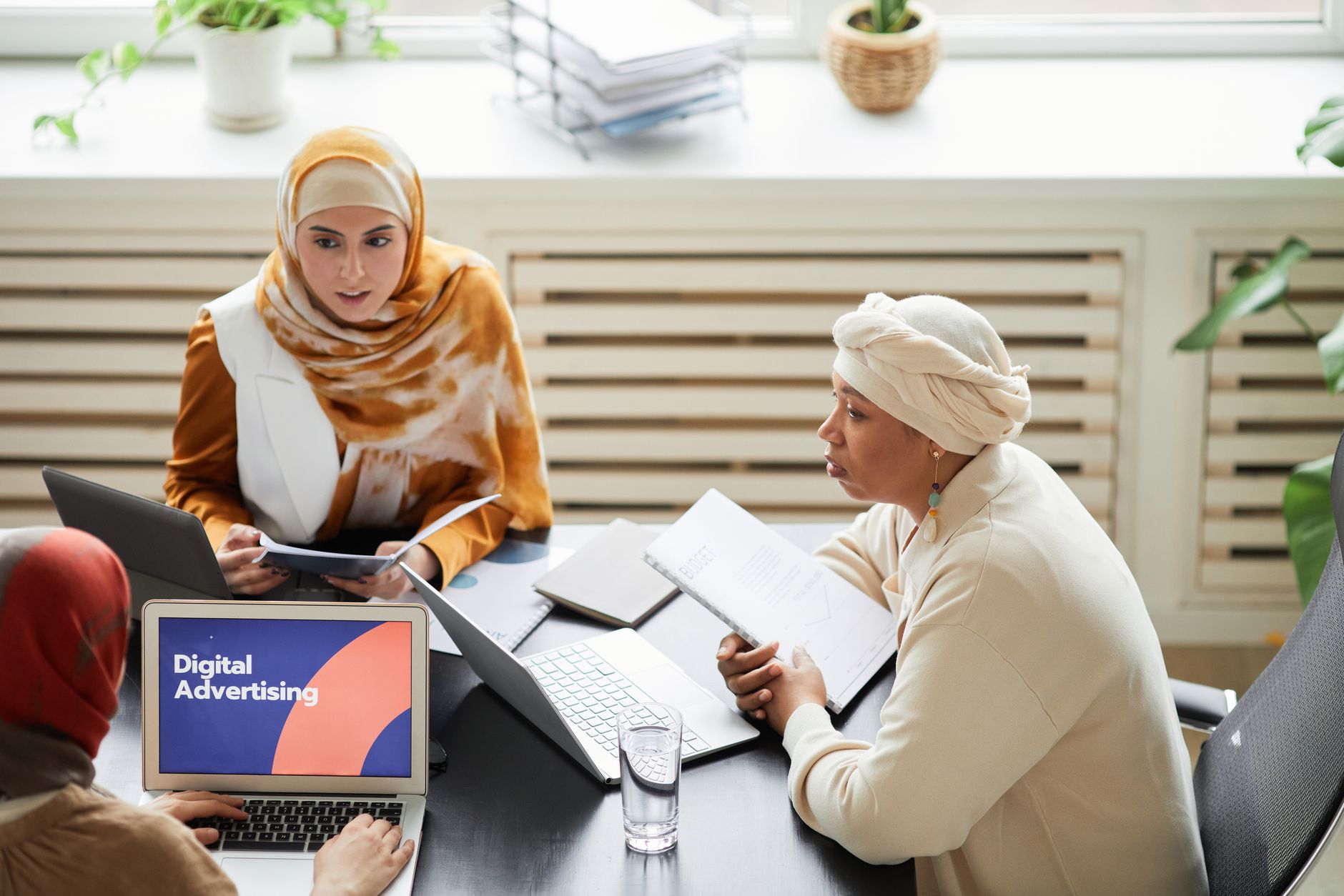 A small marketing team gathered around a laptop during a collaborative work session