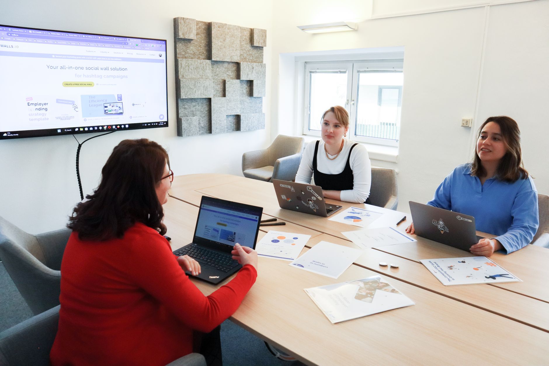 A small marketing team reviewing campaign data on a laptop during a meeting