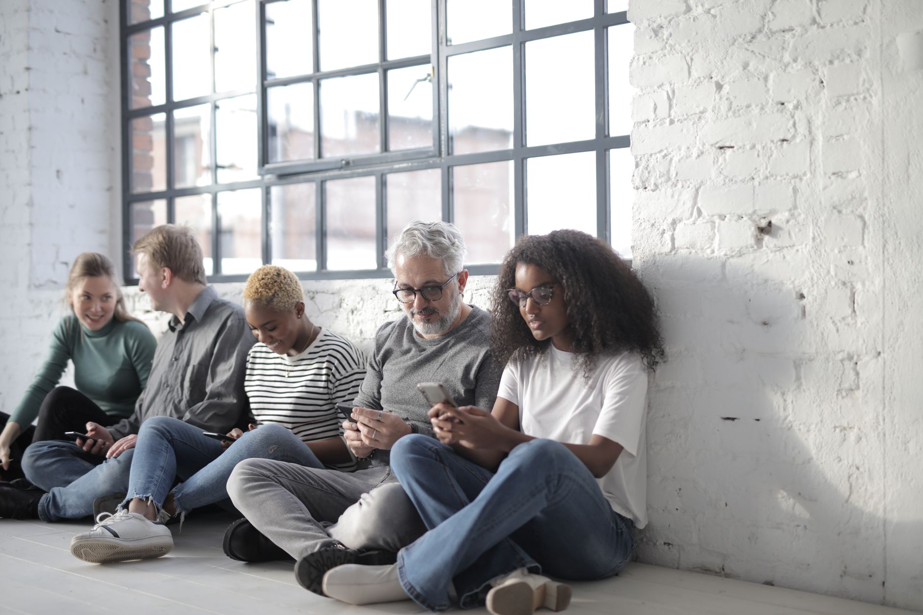 A social media marketing team collaborating around a laptop reviewing content drafts