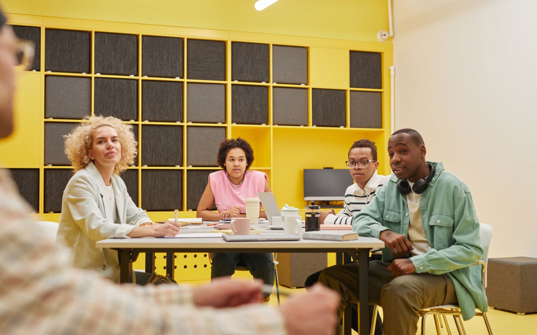 A small marketing team reviewing creative content on a monitor in a modern office