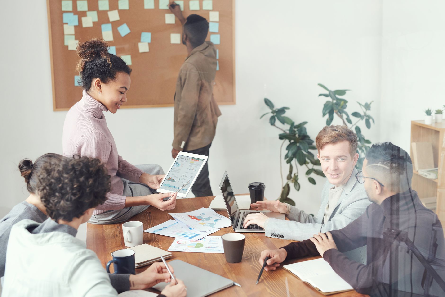 A small marketing team reviewing video content on a laptop in a modern office