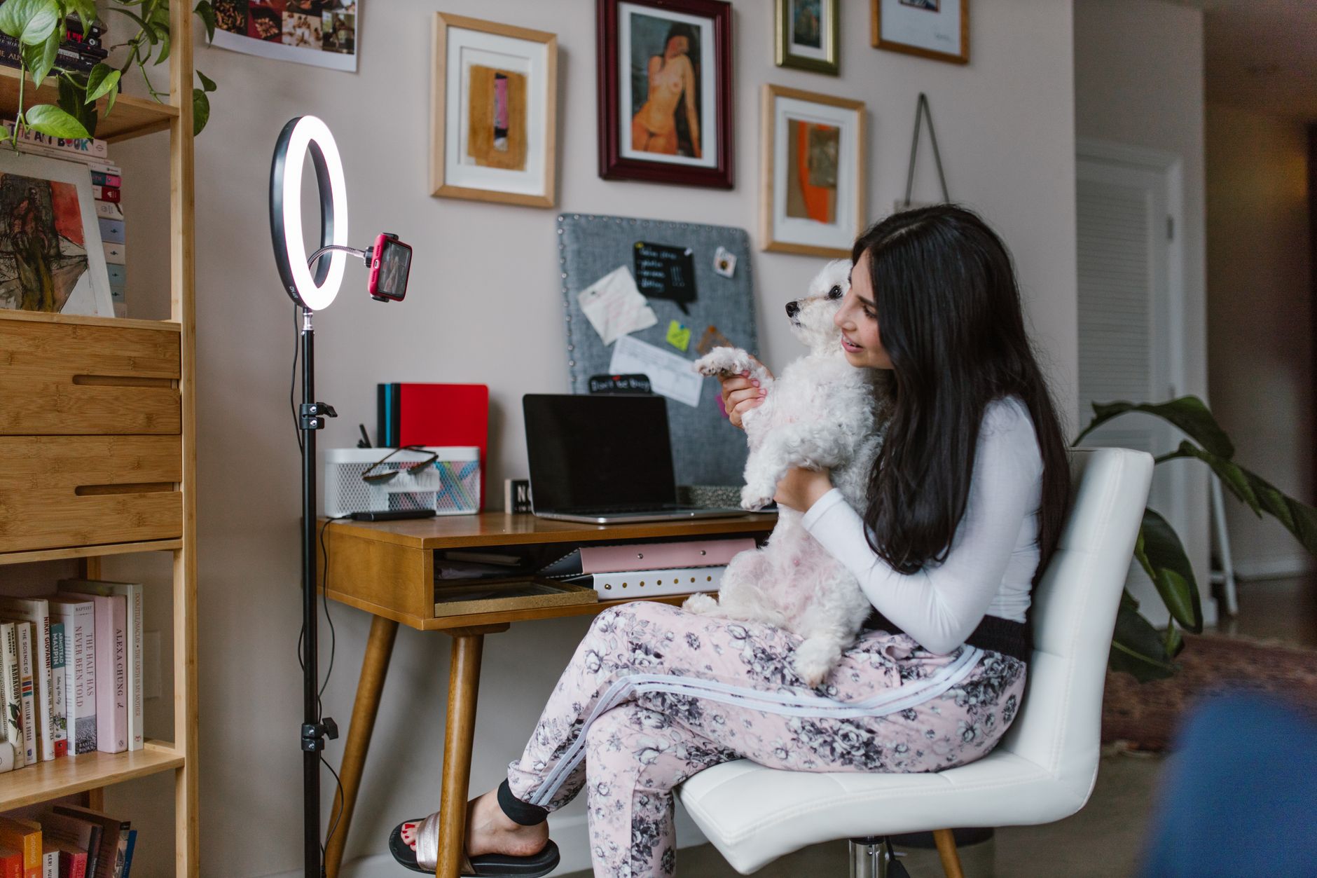 Content creator working at a home desk with monitor and notebook