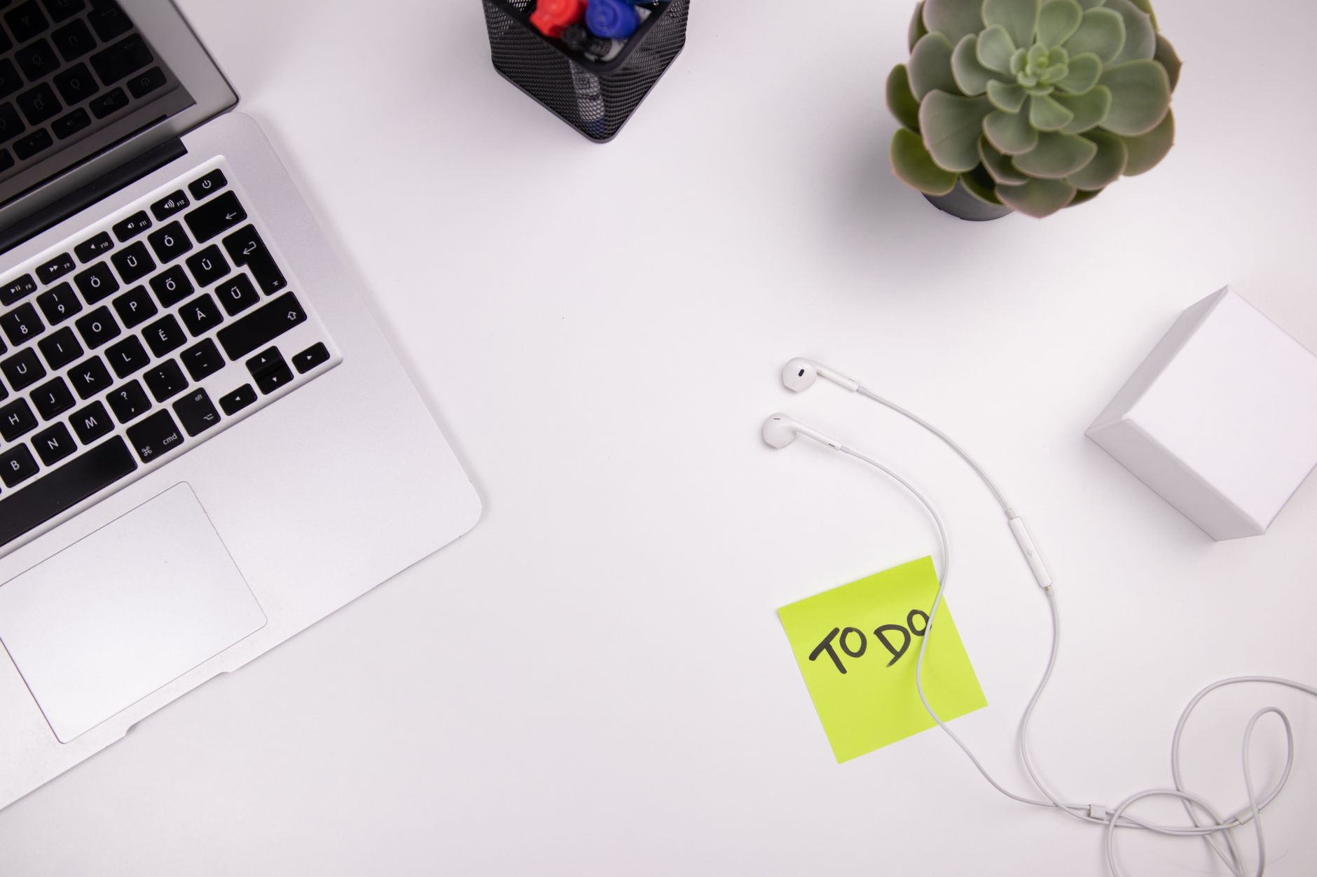 A marketer planning a content workflow with a notebook and laptop open on a desk