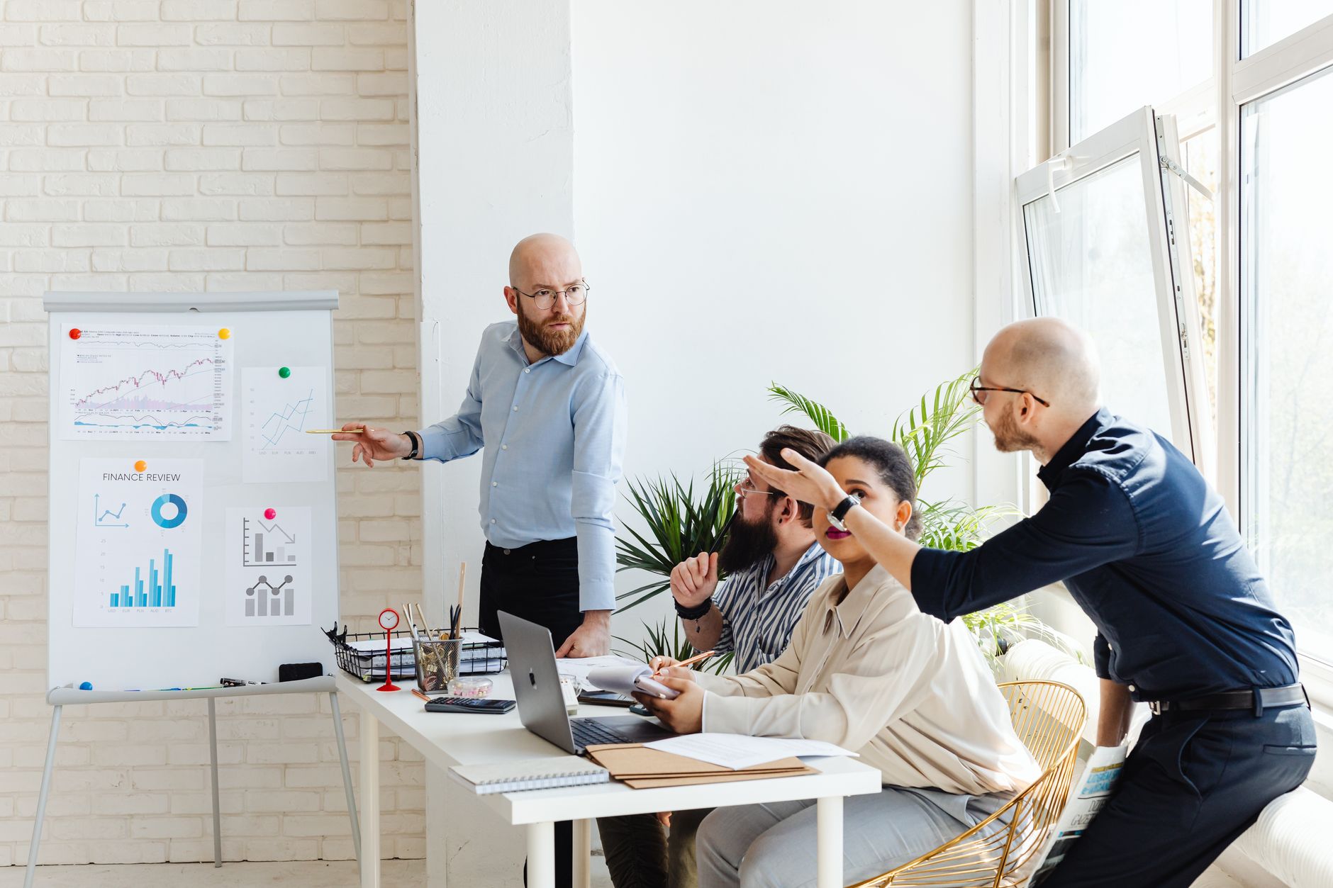 Marketing team members reviewing reports and digital tools at an office workstation