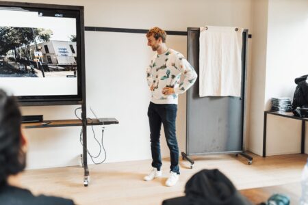 Founder presenting a pitch deck on a screen during a startup meeting