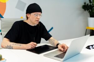 A designer working on social media content using a laptop at a clean desk workspace