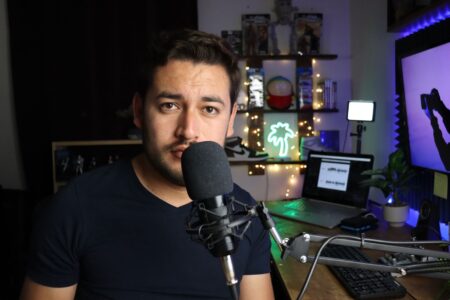 Solo content creator working at a minimalist home desk with laptop and notebook