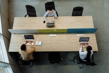 Content team members collaborating around a shared workspace with laptops and notes