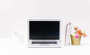 Blogger working at a laptop desk setting up social media scheduling tools