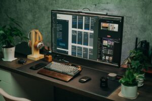 A solopreneur working at a minimalist desk with a laptop and social media analytics on screen