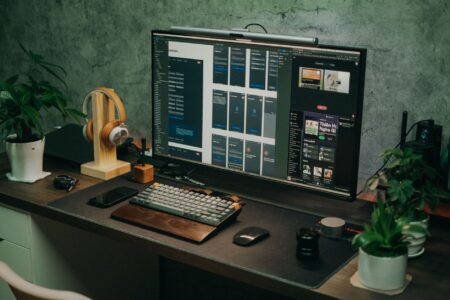 A solopreneur working at a minimalist desk with a laptop and social media analytics on screen