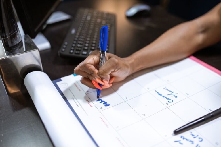 A desk with a calendar and planning materials representing team scheduling workflows