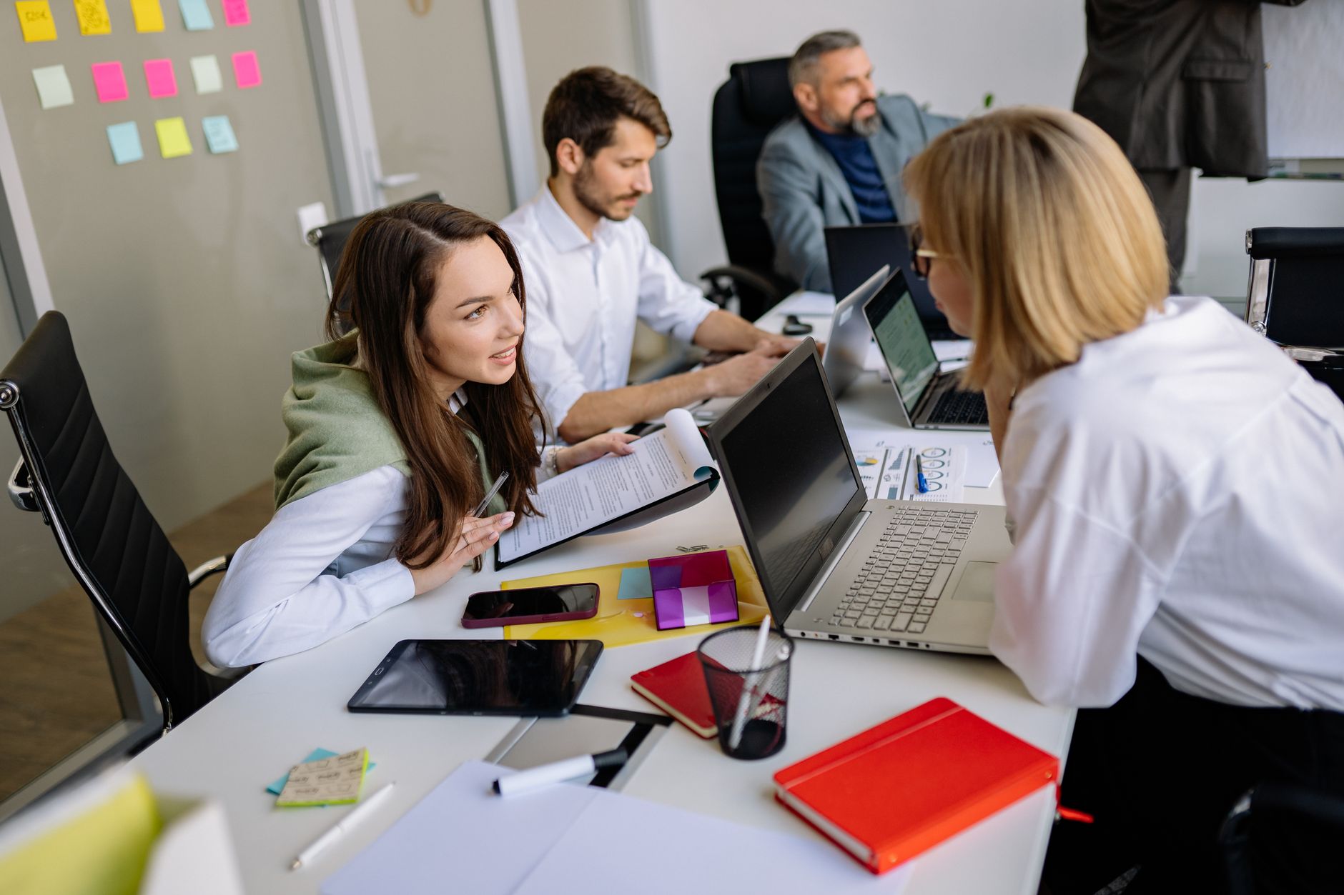 A marketing agency team working together at office desks reviewing digital content on screens