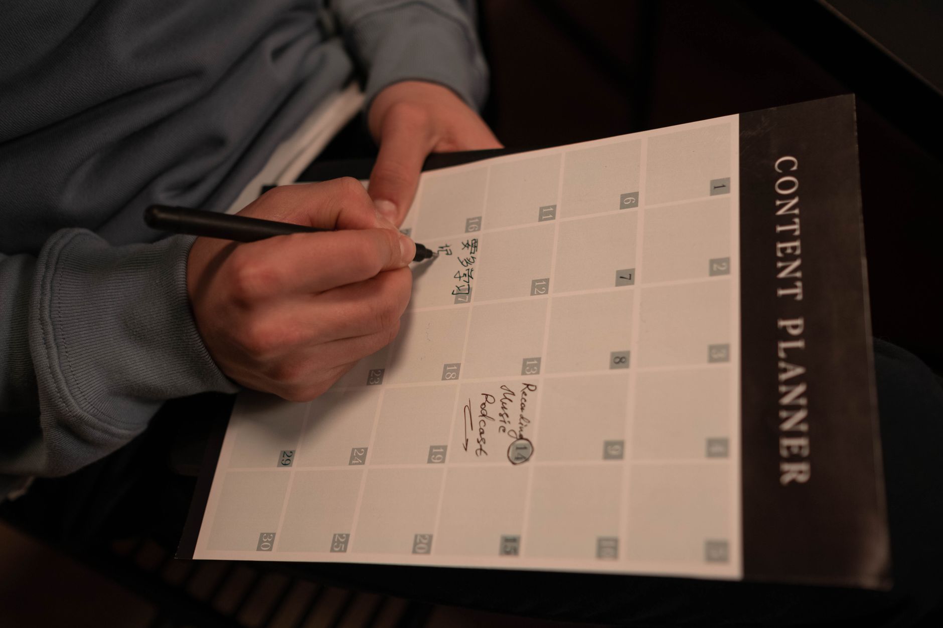 Open planner and laptop on a desk showing a digital content calendar for social media