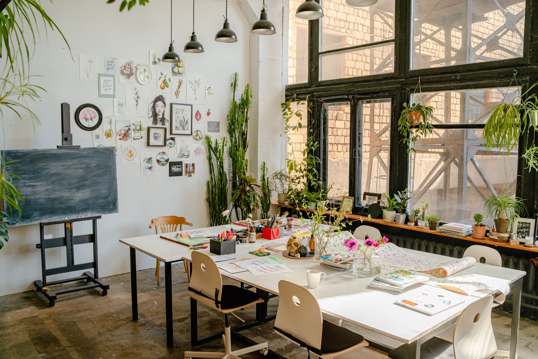 A modern creative studio workspace with multiple screens showing design and publishing tools