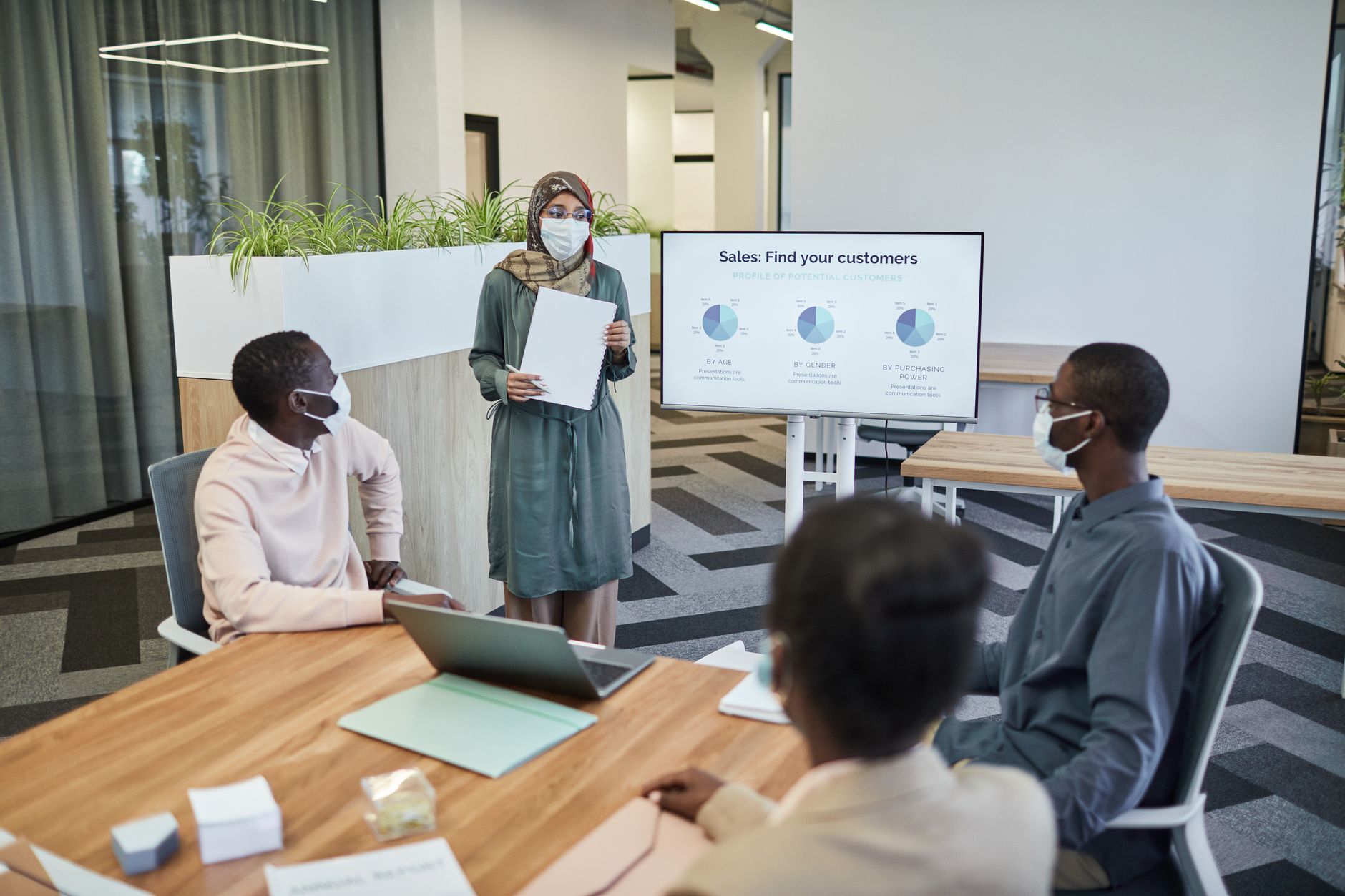 Small sales team gathered around a table discussing workflow tools