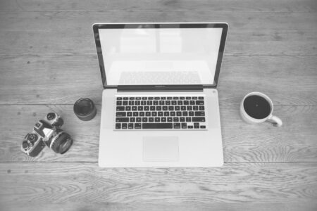 Creator working on a newsletter at a laptop in a minimal workspace