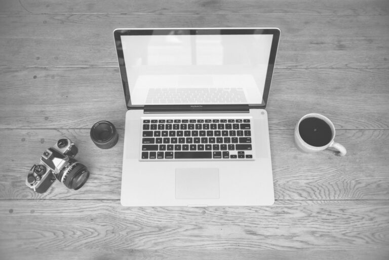 Creator working on a newsletter at a laptop in a minimal workspace