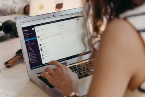 Person writing a newsletter on a laptop at a desk