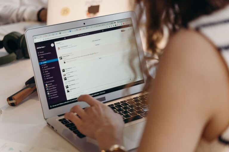 Person writing a newsletter on a laptop at a desk