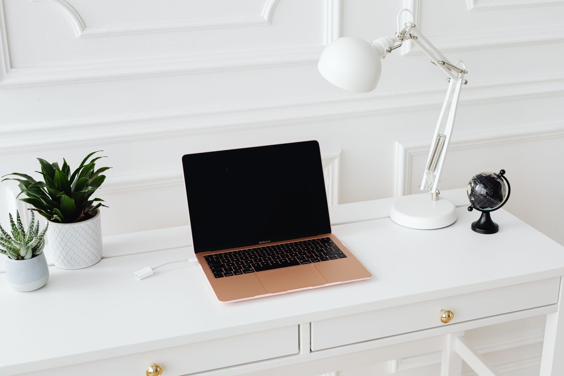 A blogger working at a home desk with a laptop and notebook open