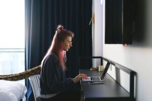 Freelancer working on a laptop at a desk managing social media accounts